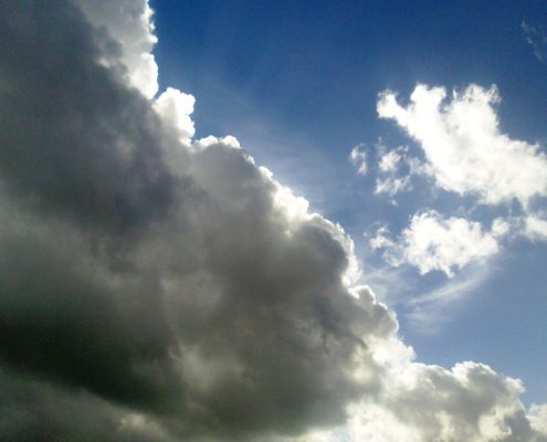 Dunkle Wolken und Licht am Himmel zur Erklärung, was Bewusstseinsarbeit ist